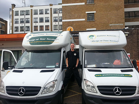 Gladiator Removal man balancing between two Removal vans.