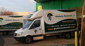 Two removal vans parked outside of a comerical buildin.